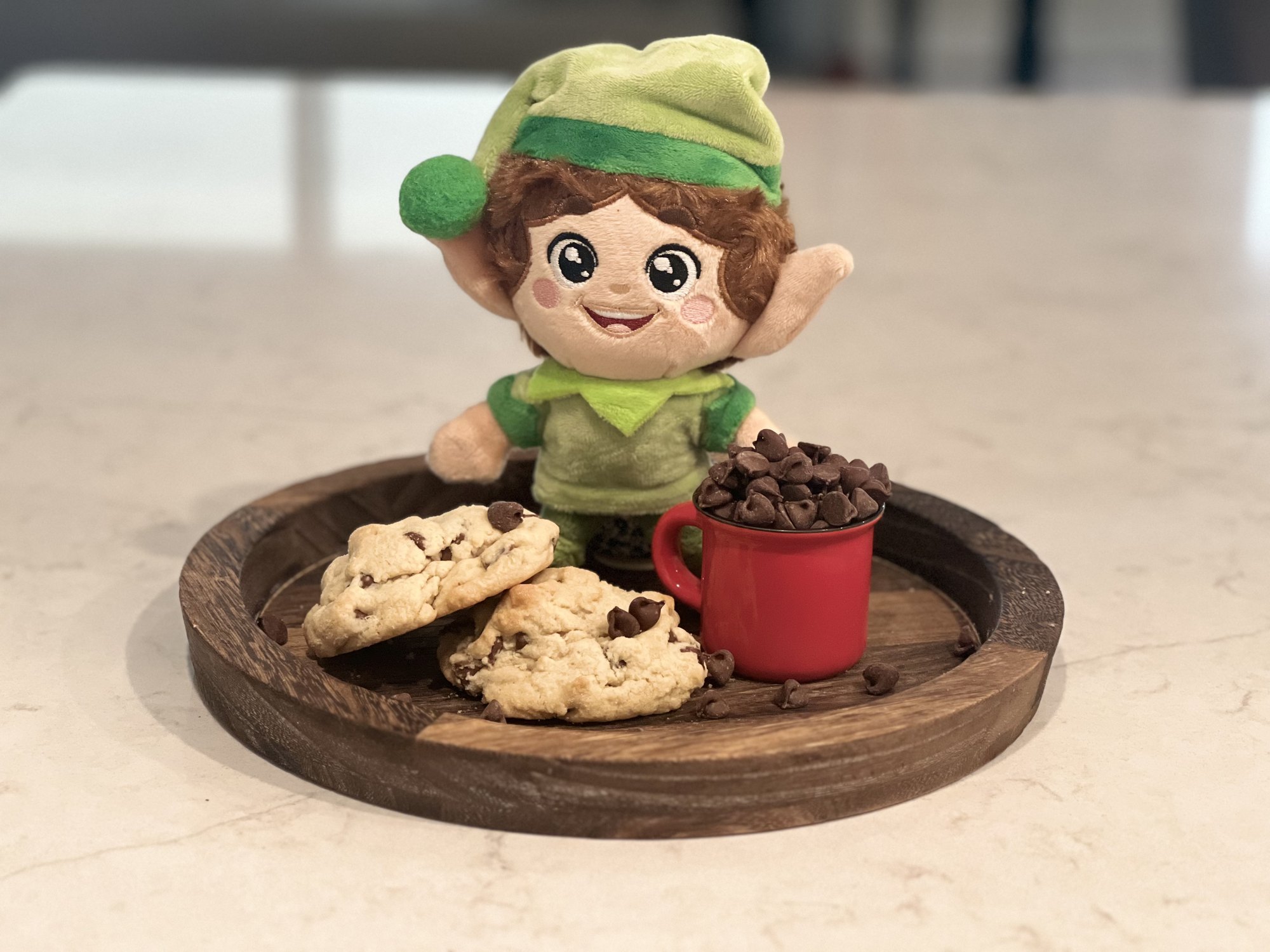 Kringle Elf with cookies and a red mug of chocolate chips
